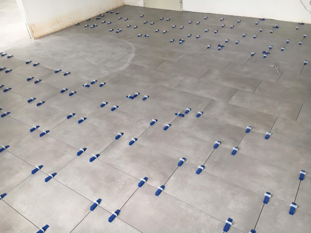 Verlegte Bodenfliesen mit Fliesen Nivelliersystem Fliesenkeile